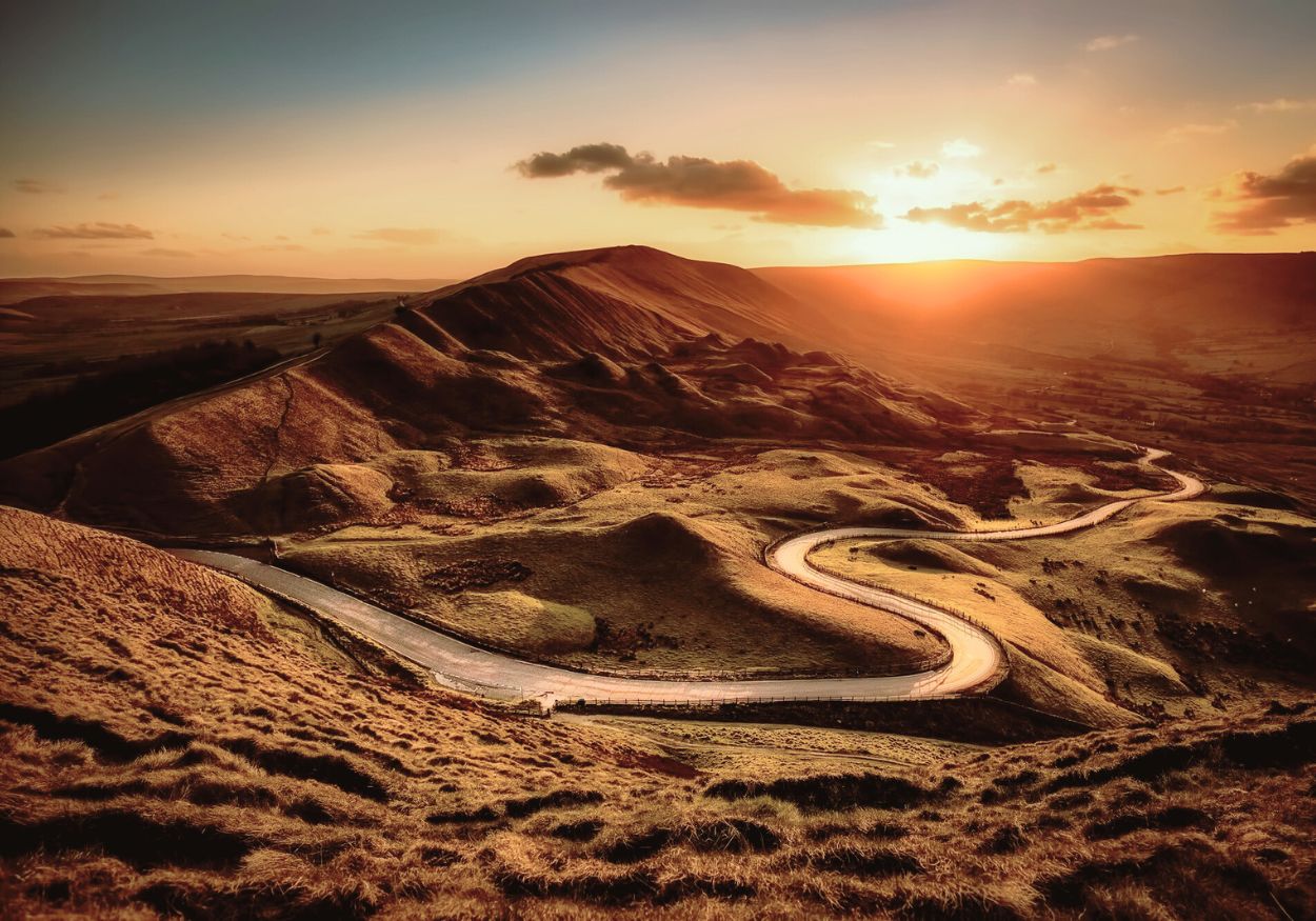 Life’s Unexpected Turns A winding road through mountains with both shadows and light