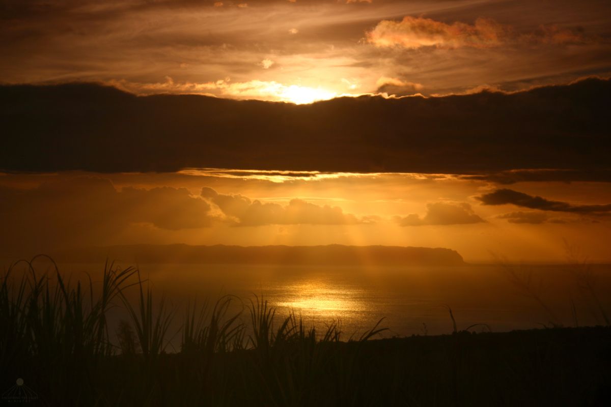 A Message of Love and Forgiveness Sunset scene with rays of light breaking through clouds, golden warm tones