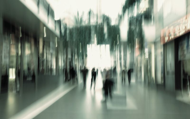 A blurred image of a busy commercial area in blue/grey hues