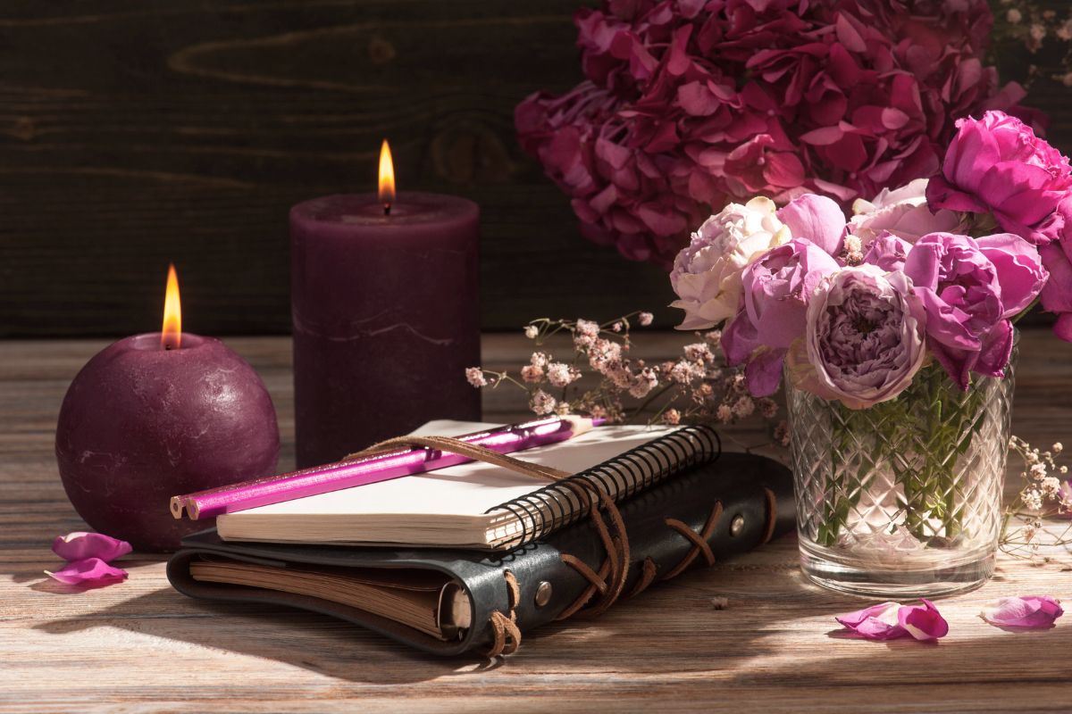 Contemplations for your heart A journal with a pen and a lit candle, representing reflection and inner work