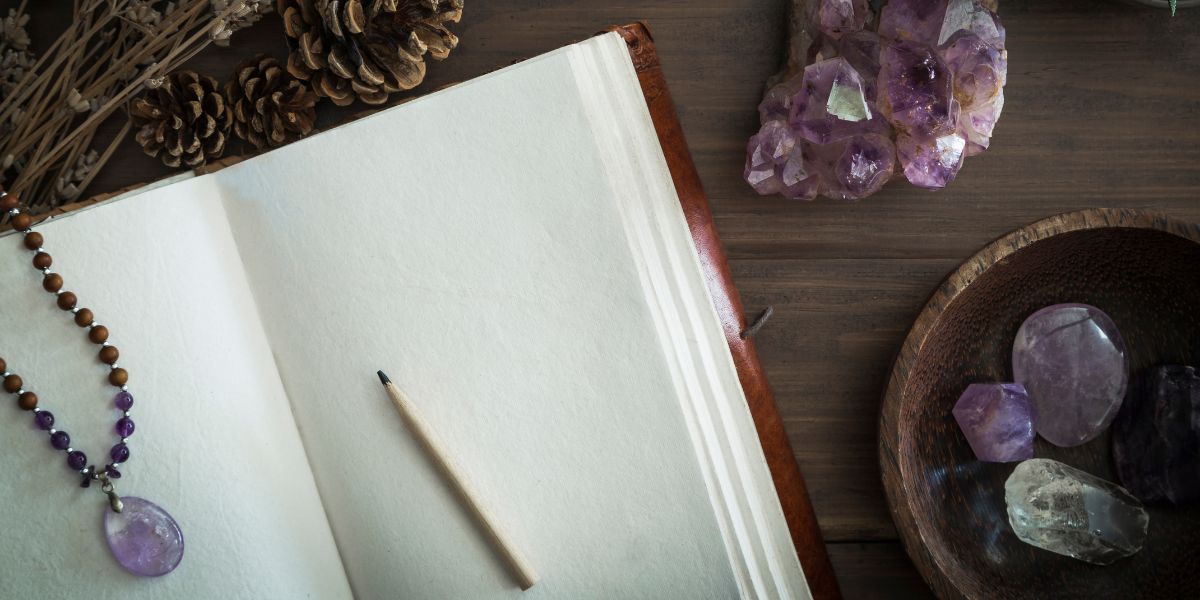 Reflection: Your Path of Resurrection A journal and pen next to a candle and crystals, inviting contemplation.